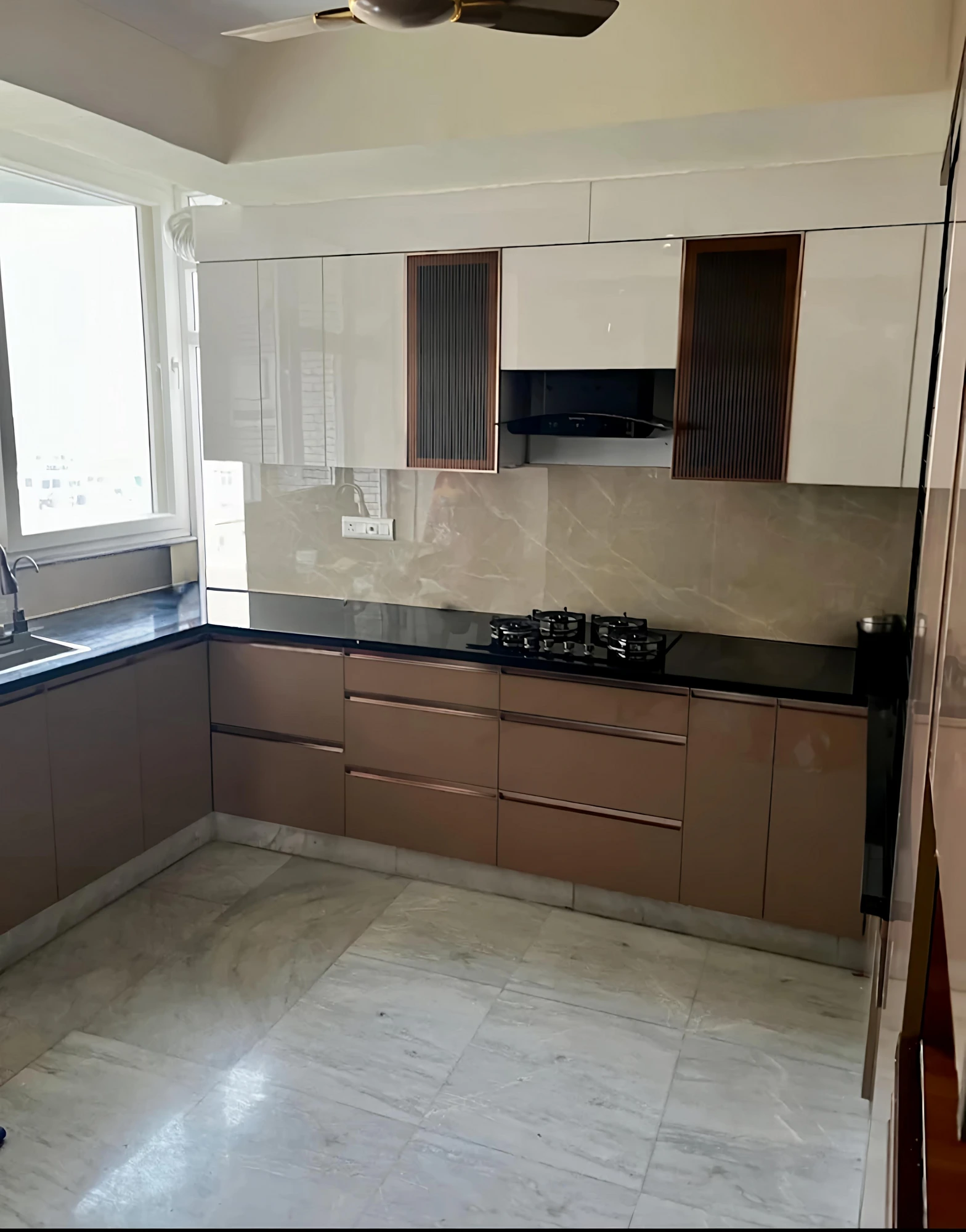 L-shaped modular kitchen with fluted glass tall units