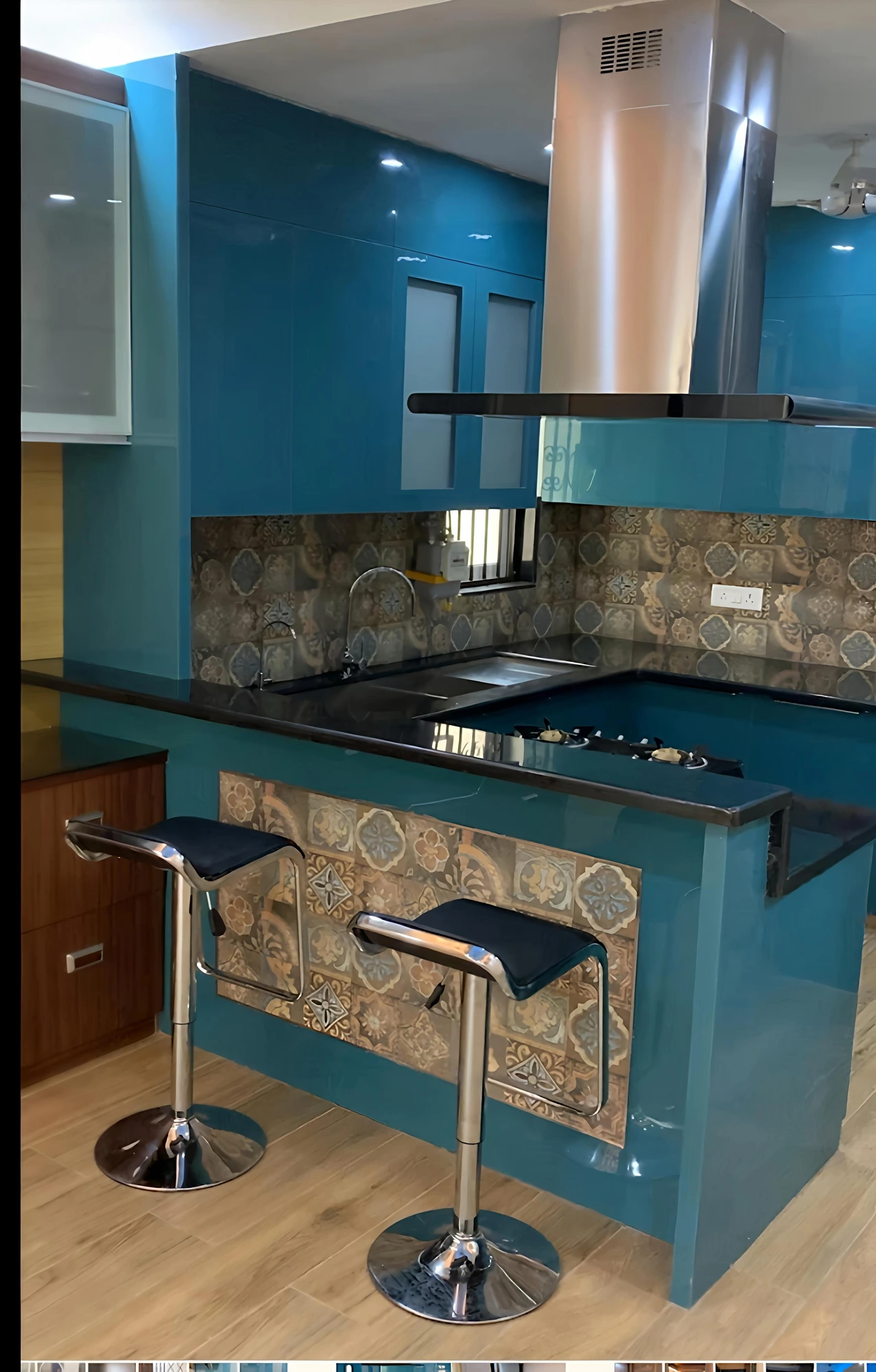 Teal island kitchen with breakfast counter and bar stools